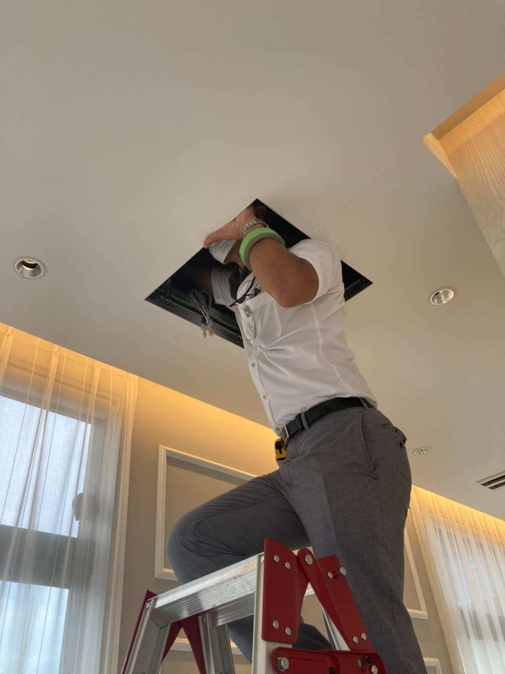 岐阜県の新築歯科医院にて、雨漏り原因特定のため診療室の天井点検口から天井裏へ侵入調査を行う様子